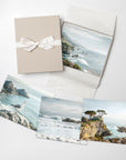 Set of 4 prints with coastal scenery and a gift box on a white background