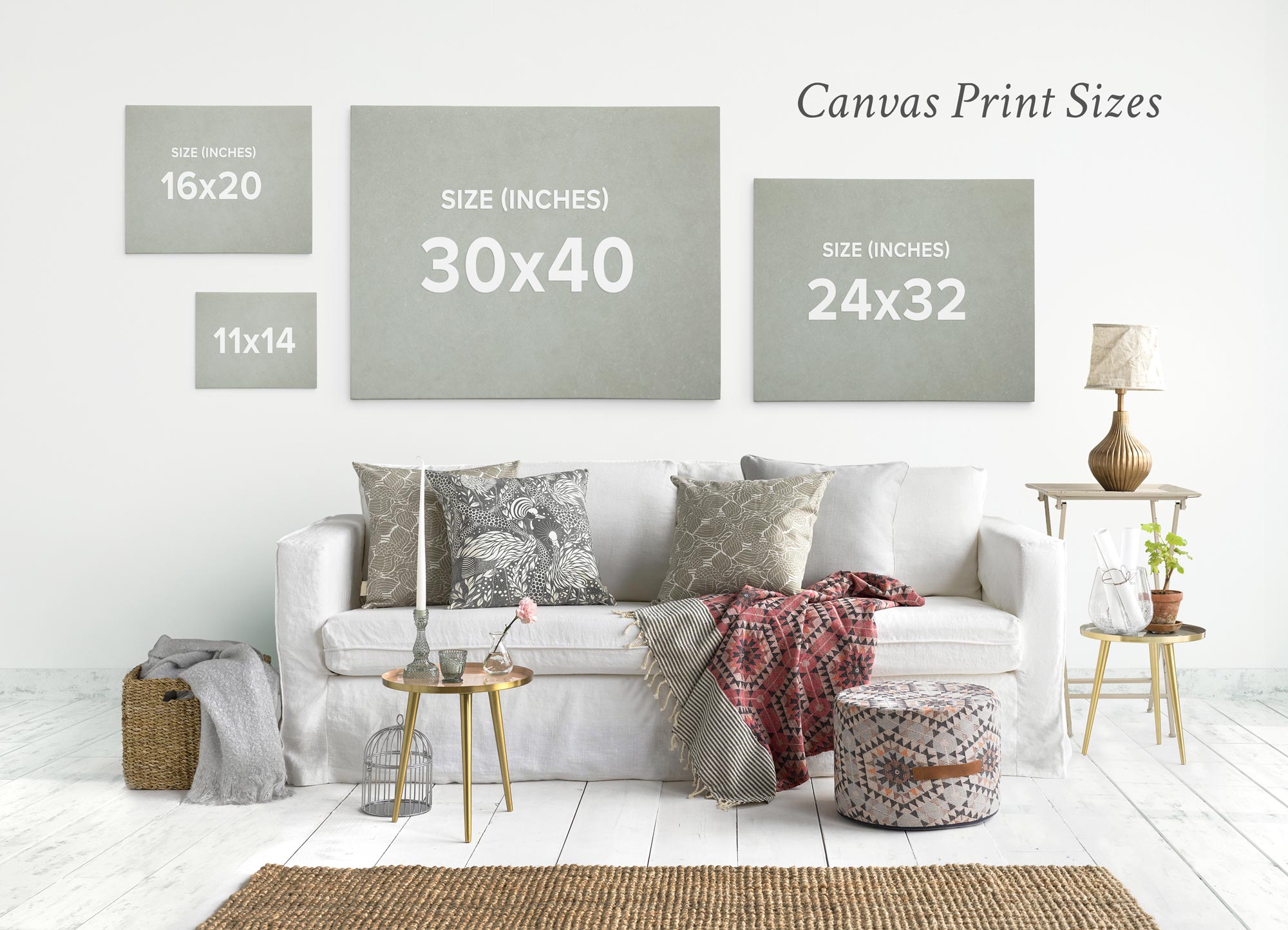 A living room scene displaying four canvas print sizes. On the wall above a white sofa, there's captivating wall art with an Offley Green 16x20 California Canvas Print (Choose from 10+ Designs), an 11x14 inch print, a 30x40 inch print, and a 24x32 inch print. The room features neutral tones with decorative pillows, a small side table, and a pouf.