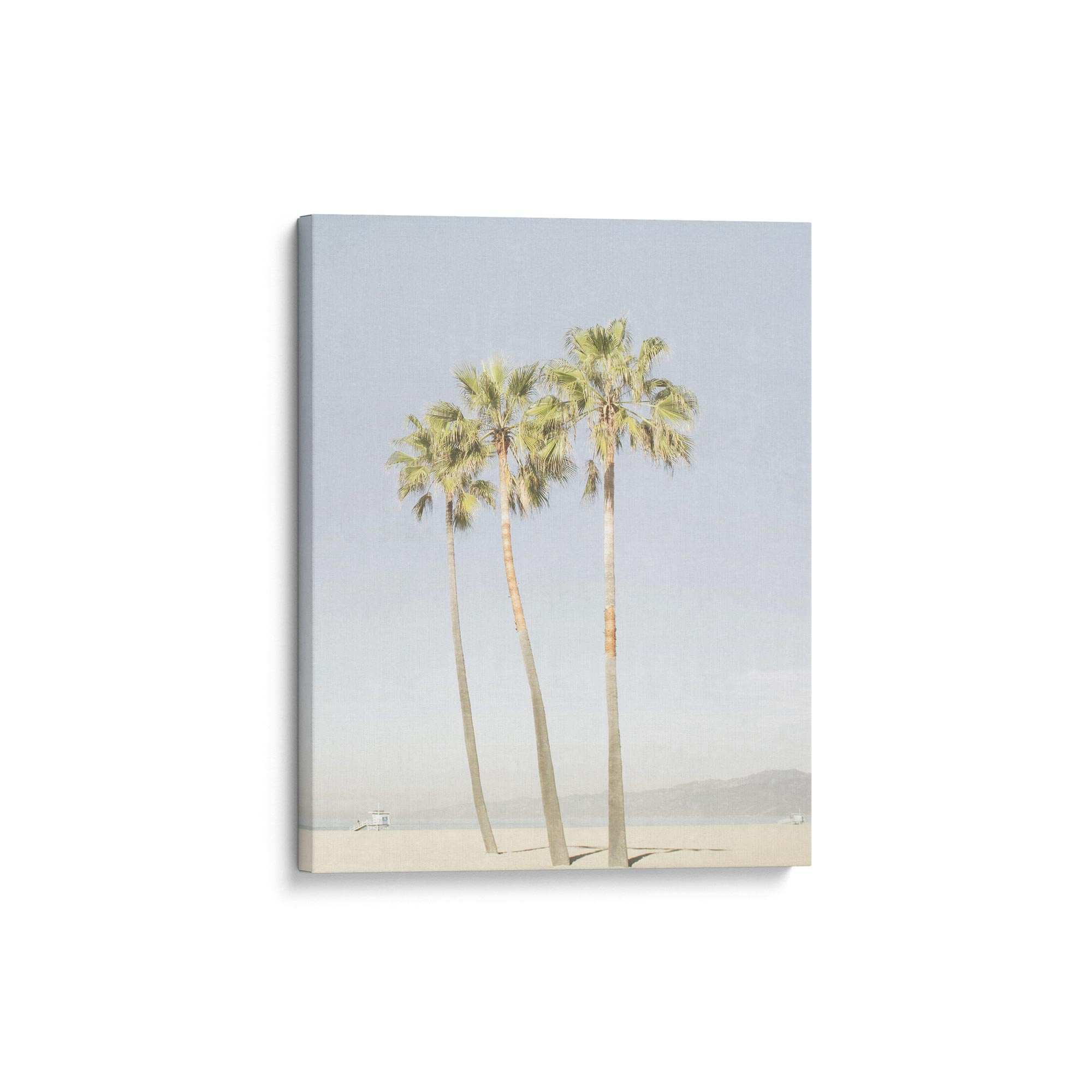 Offley Green's Set of 3 Canvas features a minimalist design with three tall palm trees on a sandy beach and a distant boat beneath a light blue sky. Made from FSC-certified materials, it's both beautiful and eco-friendly.