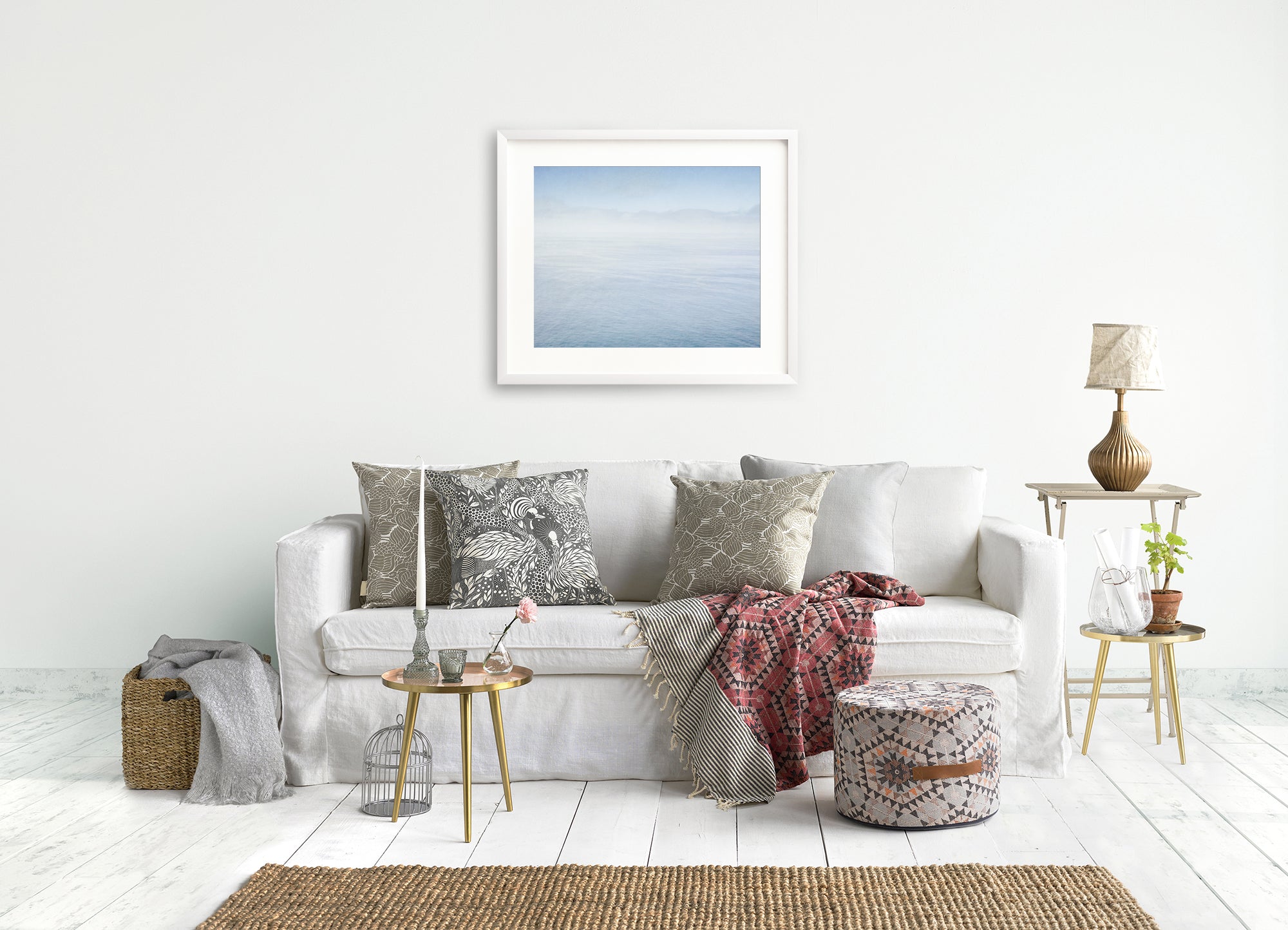 Ocean Blue Wall Art in a white picture frame hanging above a comfy bohemian sofa.