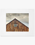 Framed photograph of a Farmhouse Rustic Print, 'Old Barn at Bodie' by Offley Green, set against a cloudy sky, printed on archival photographic paper.