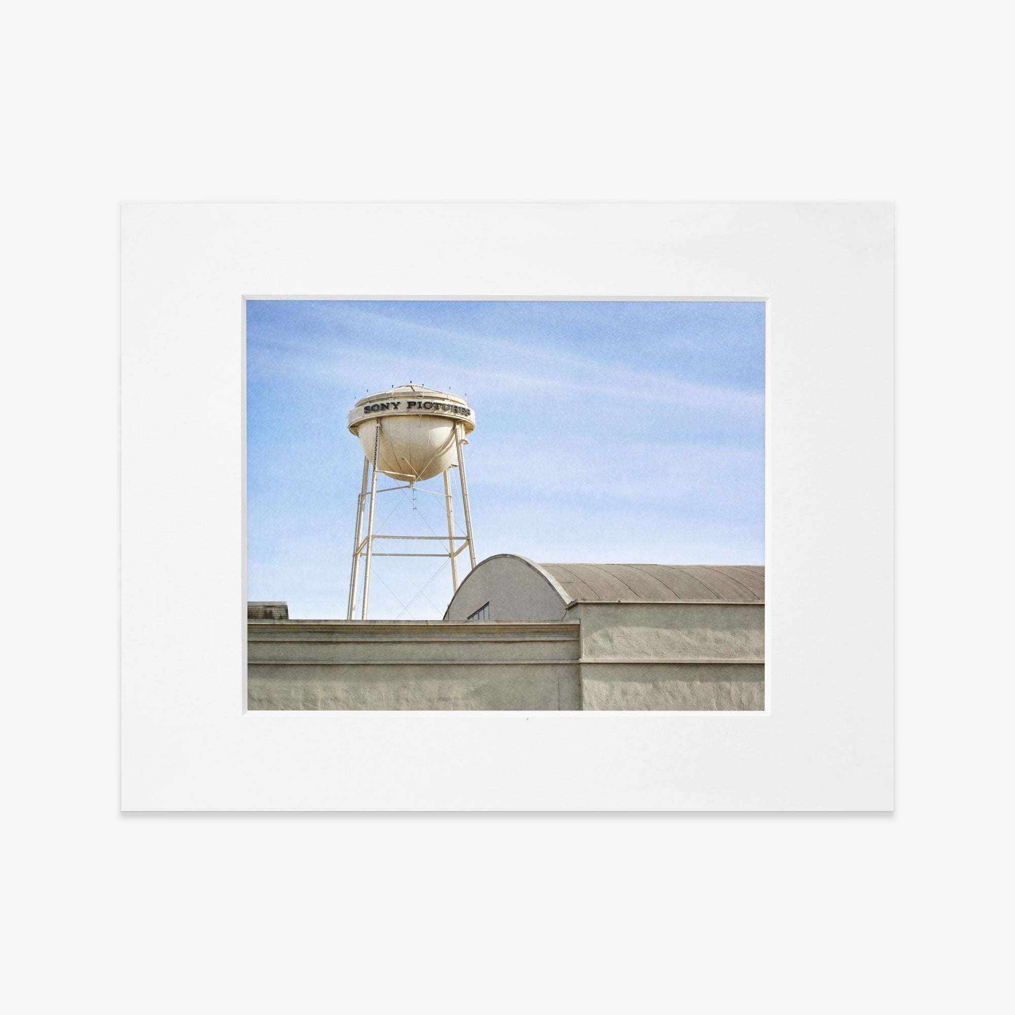 An unframed Los Angeles Sony Pictures Studio Print featuring an aged water tower with the text &quot;rock products&quot; atop a flat-roofed industrial building against a clear sky.