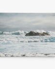 The Offley Green 16x20 Coastal Canvas Print features a serene ocean scene with waves against rocks and an overcast sky, offering a muted, tranquil atmosphere perfect for coastal prints. Choose from 10+ designs for your canvas gallery wrap.