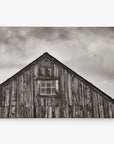 The 8x10 Rustic Canvas Print by Offley Green features a monochrome image of a rustic wooden barn with a multi-pane window and dramatic cloudy skies, perfect for creating evocative rustic prints. Choose from 10+ designs.