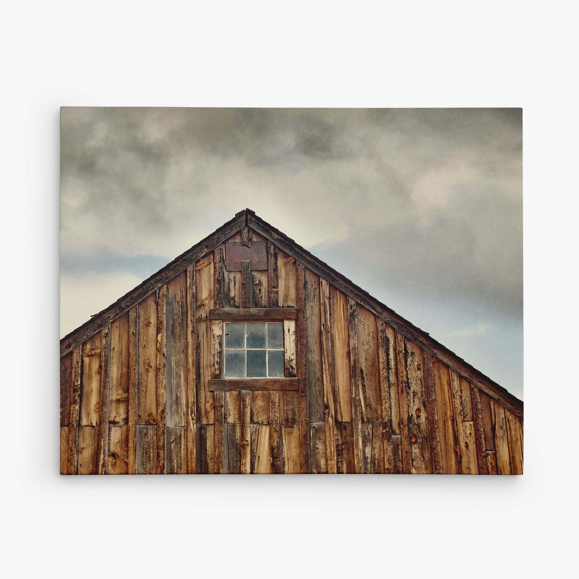 The Offley Green 8x10 Rustic Canvas Print, featuring a wooden barn under a cloudy sky, captures the weathered brown tones of wood for an authentic texture, reminiscent of charming rustic art. Choose from 10+ designs to bring this canvas gallery wrap into your space.