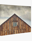 Offley Green's 8x10 Rustic Canvas Print features a weathered wooden barn against a cloudy sky. The warm brown FSC-certified wood frames a central window beautifully. Choose from 10+ designs.