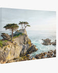 The 16x20 Coastal Canvas Print by Offley Green captures a rocky coastline with isolated trees and waves crashing against the rocks under a clear sky, offering a serene view perfect for highlighting nature's timeless beauty. Choose from 10+ designs to enhance your space.