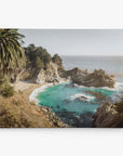 The Offley Green 16x20 Coastal Canvas Print captures a rocky coastline with a small beach, turquoise water, tall palm trees, and dense greenery from FSC certified forests under a clear sky—perfect for coastal décor. Choose from 10+ stunning designs to adorn your space.