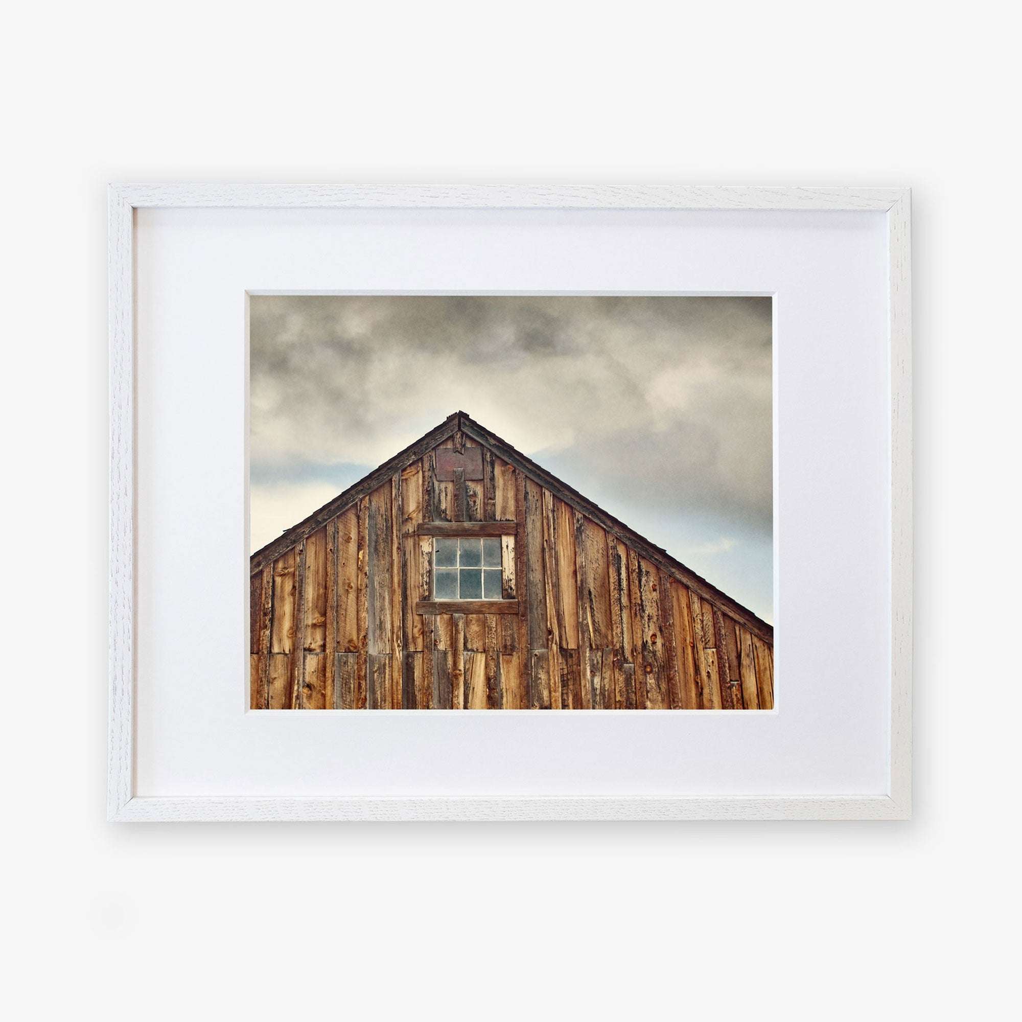 A framed photograph of an Offley Green &#39;Old Barn at Bodie&#39; farmhouse rustic print, displayed against a white background. The barn has weathered planks and a single small window.