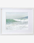 A framed Breaking Surf print of a vibrant ocean wave cresting at a Southern California beach, displayed in a simple white frame against a white background by Offley Green.