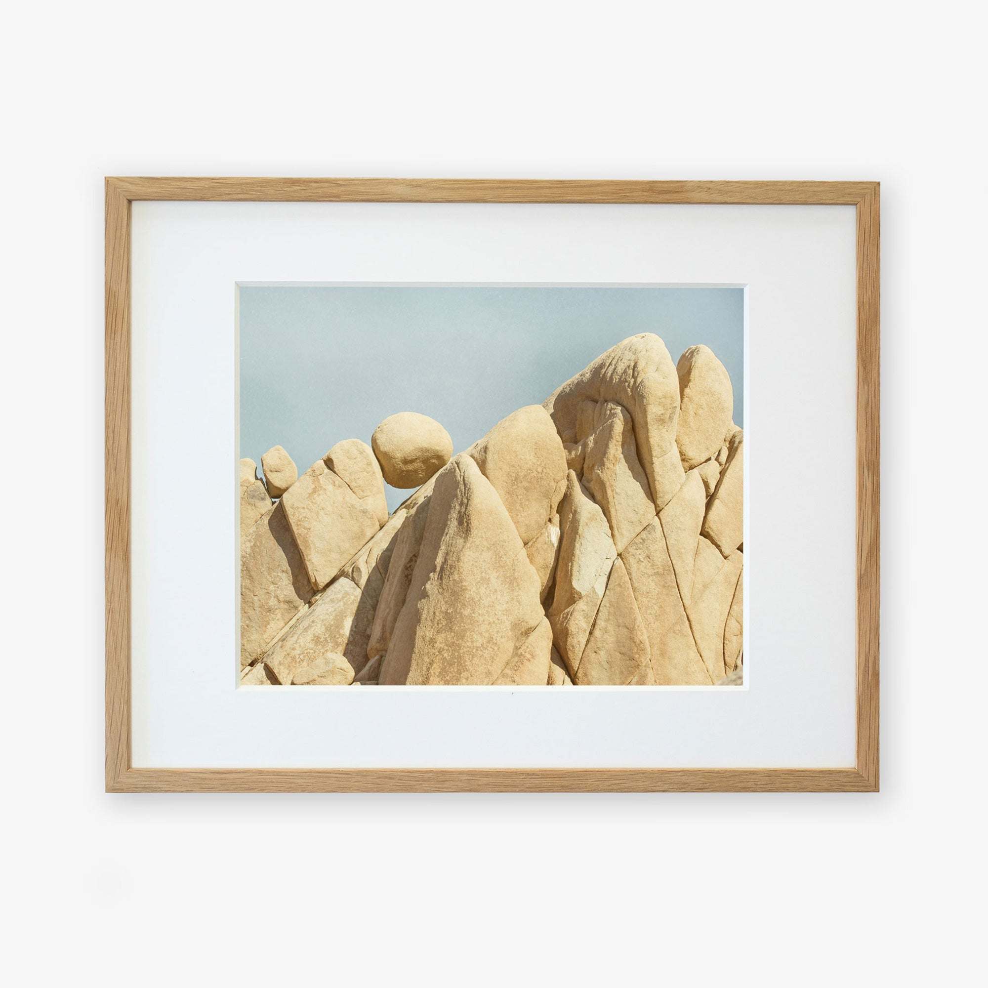 A framed Offley Green Joshua Tree Print, 'Rock Formations', displayed in a wooden frame with a white mat.