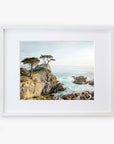 A framed painting of a California Coastal Print, 'Lone Cypress' with rugged cliffs, choppy sea, and windswept trees under a bright sky at Pebble Beach, displayed on a white background by Offley Green.