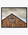 A framed photograph of the upper part of an old wooden barn with a single window, set against a cloudy sky, printed on archival photographic paper - Offley Green's Farmhouse Rustic Print, 'Old Barn at Bodie'.