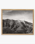 Black and white photo of the Offley Green Hollywood Sign Black and White Vintage Print, 'Old Hollywood' on a hill, printed on archival photographic paper, framed in a wooden picture frame, with a clear sky in the background.