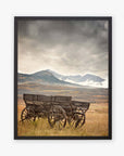 The Offley Green 'Old Wagon' Rustic Farmhouse Wall Art features a rustic wagon set in a tranquil field, with misty mountains and cloudy skies enhancing its timeless charm.