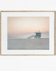 Framed photograph of a lifeguard tower on a beach at sunset.