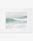 A framed photograph of a vibrant ocean wave cresting at a Southern California beach, with soft mist hovering above the water, set against a blurred coastal backdrop - Coastal Print of a Breaking Wave 'Breaking Surf' by Offley Green.