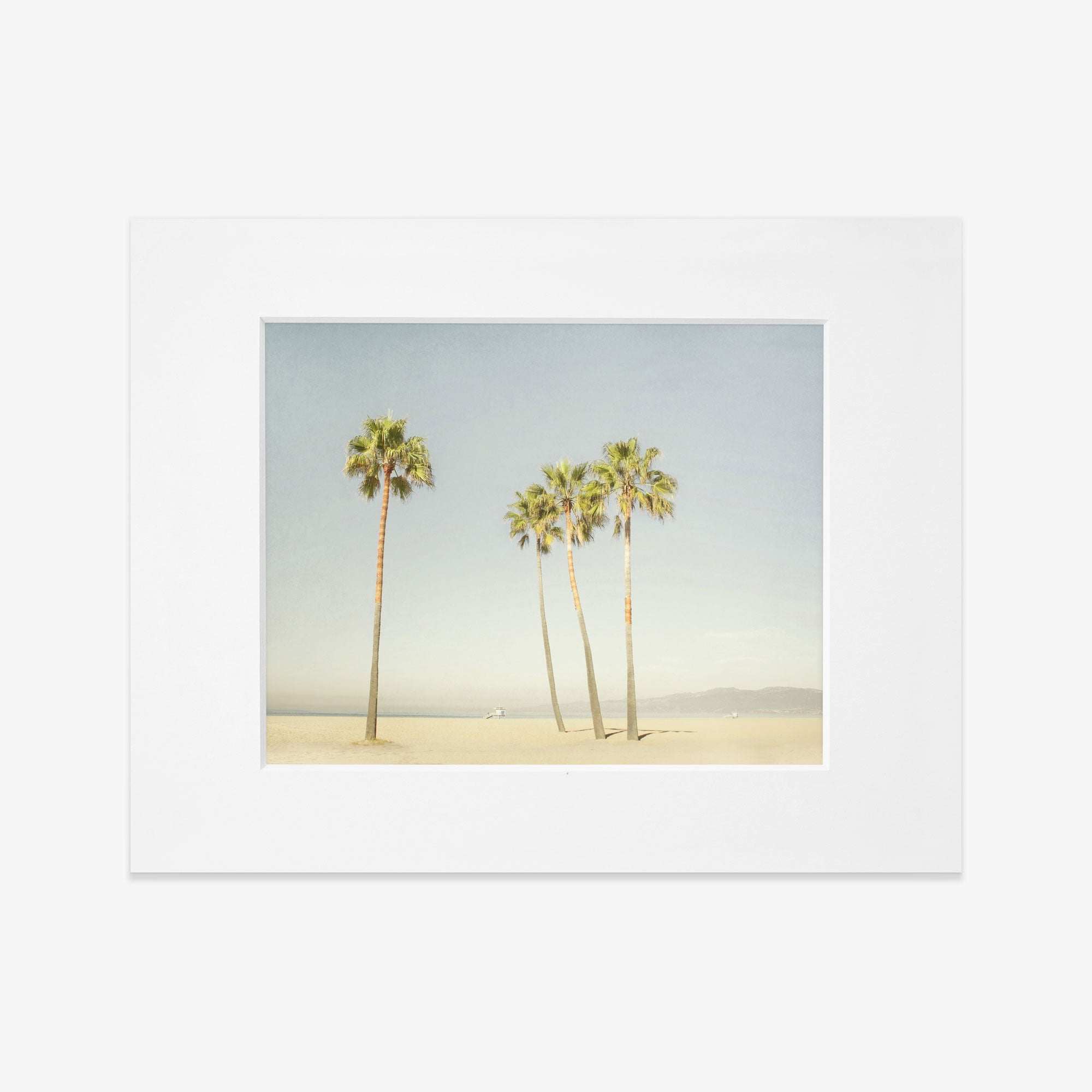 A framed photograph of four tall palm trees on Venice Beach under a clear sky. The image has a vintage, sun-bleached look, adding a nostalgic feel. The product name is California Venice Beach Print, &#39;Boardwalk Palms&#39; by Offley Green.