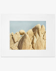 An unframed Joshua Tree Print, 'Rock Formations' photograph by Offley Green of unusual, rounded beige rock formations against a clear blue sky. The natural textures and lines on the rocks are distinctly visible.