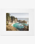 Framed photograph of a Big Sur Coastal Print, 'Julia Pffeifer' featuring rugged cliffs along the Pacific Coast Highway, a turquoise sea, and a sandy beach flanked by green palm trees by Offley Green.