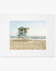 Framed photograph of a vibrant lifeguard tower numbered 38, set on a sandy beach with gentle waves in the background, under a clear blue sky on the California coastline. 
Product Name: Offley Green's California Coastal Print, 'Carlsbad Lifeguard Tower'