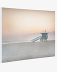 A Pink Coastal Wall Art featuring a serene beach scene at dusk with a 'Lifeguard Tower', soft pink hues in the sky, and distant mountains at Venice Santa Monica beach by Offley Green.