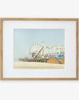 A framed illustration of a California Print, 'Santa Monica Pier' by Offley Green, with a ferris wheel and roller coaster over Santa Monica Pier, displayed against a plain background.