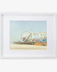 A framed illustration of Santa Monica Pier, featuring a ferris wheel and roller coaster, displayed against a calm blue sky. Get your Offley Green California Print, 'Santa Monica Pier' today!