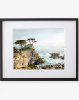 A framed painting of a rocky coastal scene with pine trees overlooking turbulent ocean waves, displayed against a white background on archival photographic paper. This is the Offley Green California Coastal Print, 'Lone Cypress'.