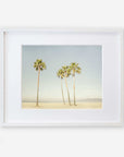 An unframed California Venice Beach Print of four tall palm trees on a sandy beach under a clear sky, displayed on a white wall. Brand: Offley Green 'Boardwalk Palms'