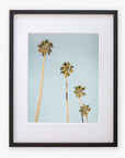 A framed Los Angeles Palm Tree Photographic Print 'Palm Stairs to Heaven' depicting four tall palm trees against a clear California sky, with the tallest tree slightly leaning to the right by Offley Green.