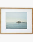 A framed photograph of Malibu Pier extending into the sea under a calm sky, displayed against a white background - Offley Green's Coastal Print of Malibu Pier in California 'All Calm in Malibu'
