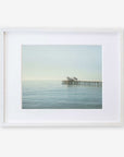A framed photograph of a peaceful seascape with Malibu Pier extending into calm waters, displayed against a white background - Coastal Print of Malibu Pier in California 'All Calm in Malibu' by Offley Green.