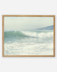 A framed painting of a calm Southern California beach scene with gentle waves and a hazy coastline in the background, giving a tranquil and serene vibe: Offley Green's Coastal Print of a Breaking Wave 'Breaking Surf'