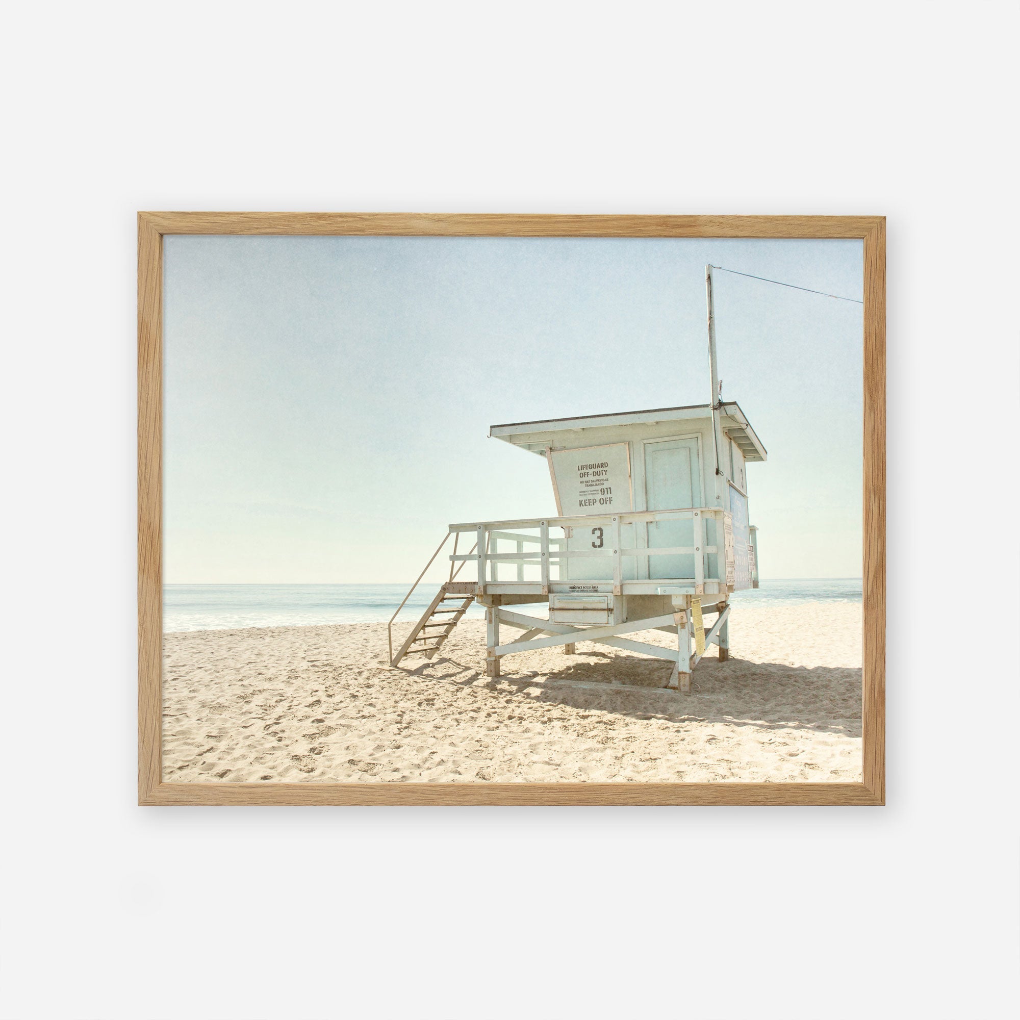 An unframed image of a lifeguard tower on a sandy beach under a clear sky, with the ocean in the background. The tower is painted white with details indicating it is tower number 3.
Product Name: Offley Green&#39;s California Summer Beach Art, &#39;Malibu Lifeguard Tower&#39;