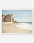 Framed painting of a serene beach scene featuring prominent cliffs at Point Dume, soft sandy shore, and gentle waves breaking onto the beach under a clear sky, featuring the California Malibu Print by Offley Green.