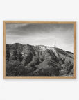Black and white photo of the Offley Green Hollywood Sign Black and White Vintage Print, 'Old Hollywood' on a hill, printed on archival photographic paper, framed in a wooden picture frame, with a clear sky in the background.