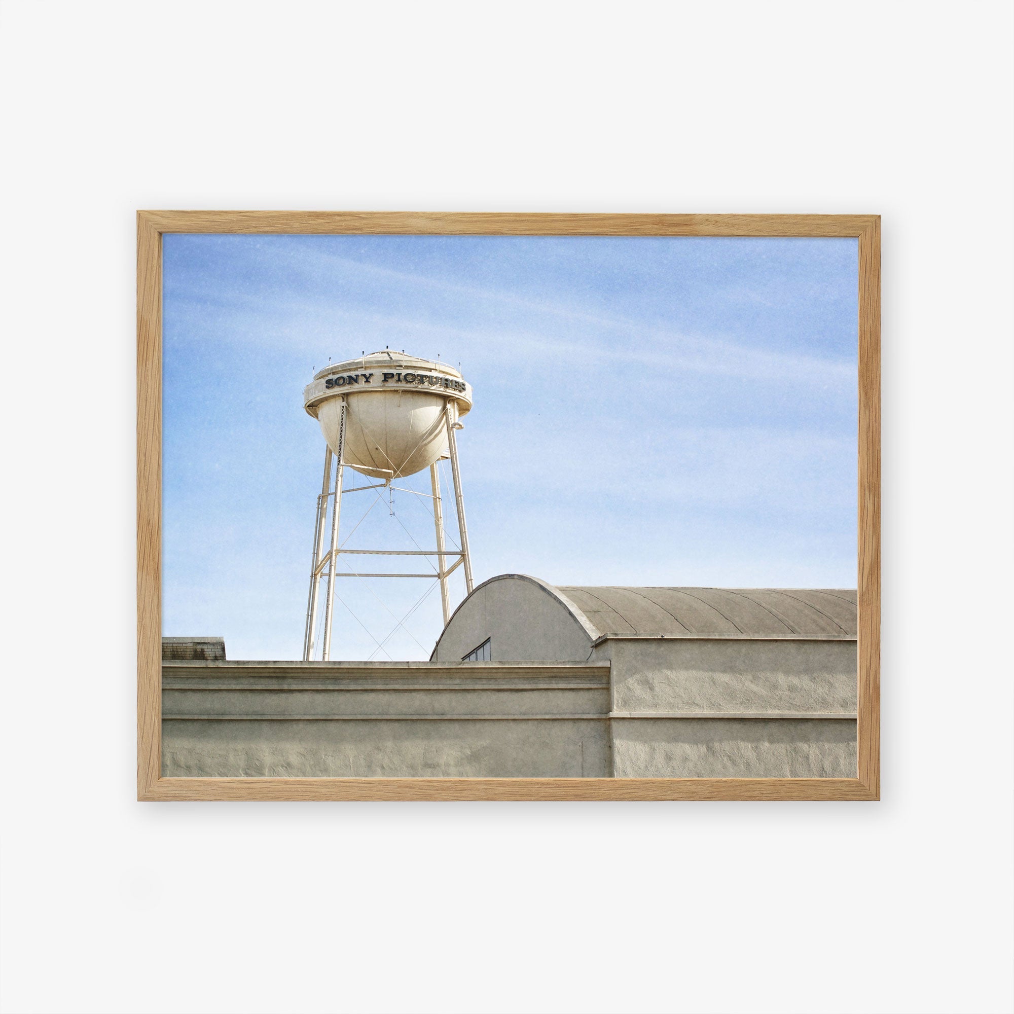 A framed photograph of an old water tower labeled &quot;Los Angeles Sony Pictures Studio Print, &#39;Sony Lot&#39;,&quot; above an industrial building against a clear blue sky by Offley Green.