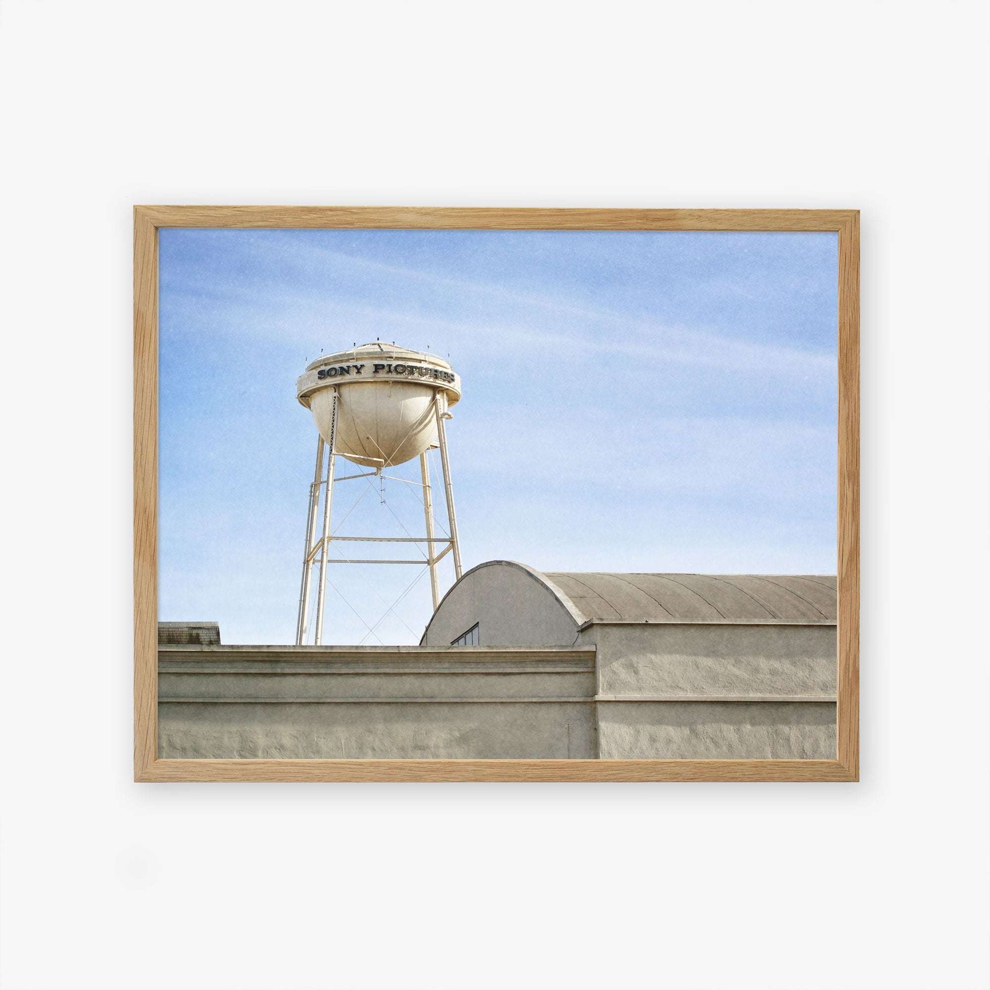 A framed photograph of an old water tower labeled &quot;Los Angeles Sony Pictures Studio Print, &#39;Sony Lot&#39;,&quot; above an industrial building against a clear blue sky by Offley Green.