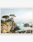 A framed painting of a rugged coastline with pine trees atop a cliff overlooking the sea at Pebble Beach, under a cloudy sky. The scene captures the serene and wild beauty of a coastal landscape. This is the Offley Green California Coastal Print, 'Lone Cypress'.
