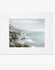 A matted print depicting a scenic coastal landscape along Big Sur with rocky cliffs and the ocean, viewed from a high vantage point under a hazy sky -  Offley Green's Big Sur Landscape Print, 'Rocky Rocks'.