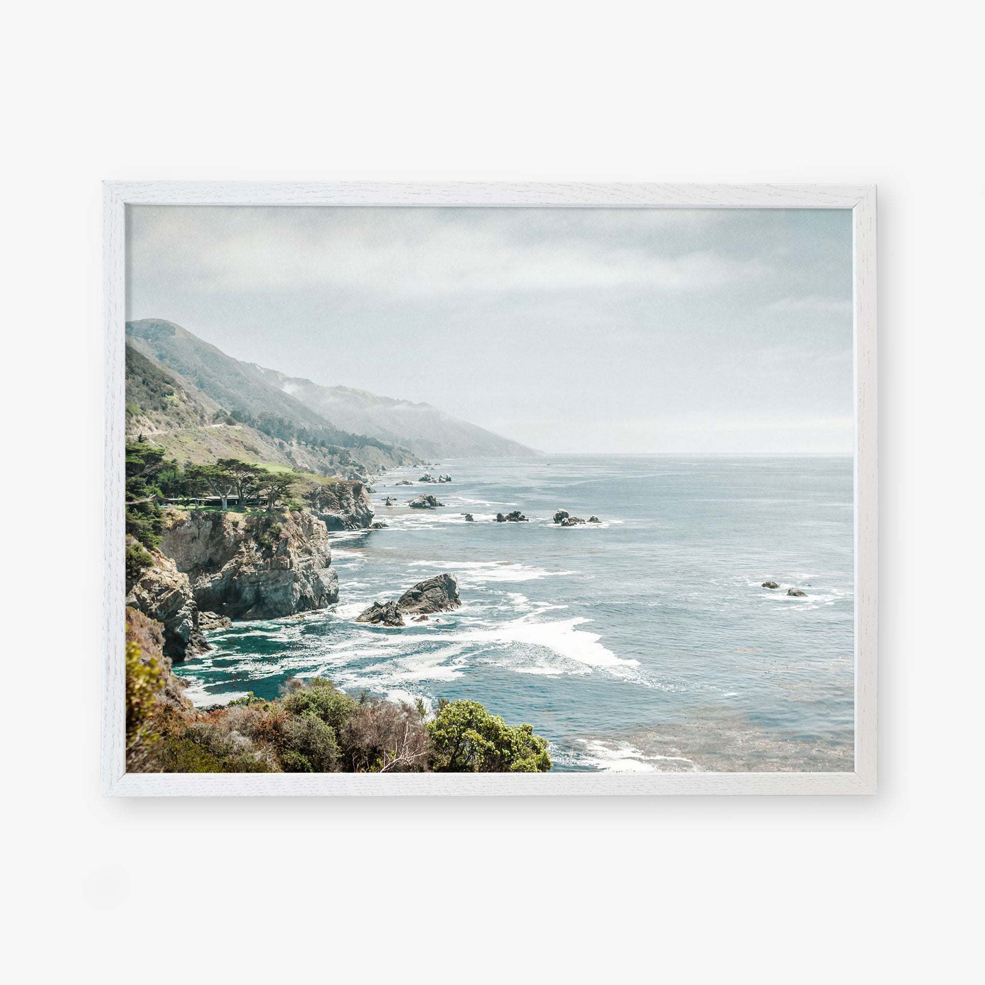 Framed artwork of a serene coastal landscape along California Highway 1, featuring rocky cliffs and a misty ocean extending into the distance under a soft, hazy sky by Offley Green&#39;s Big Sur Landscape Print, &#39;Rocky Rocks&#39;.