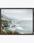 A framed archival photographic print depicting a scenic coastal view of Big Sur with rugged cliffs and a serene ocean under a hazy sky, showcasing the natural beauty of California Highway 1. This is the Offley Green 'Rocky Rocks' Big Sur Landscape Print.