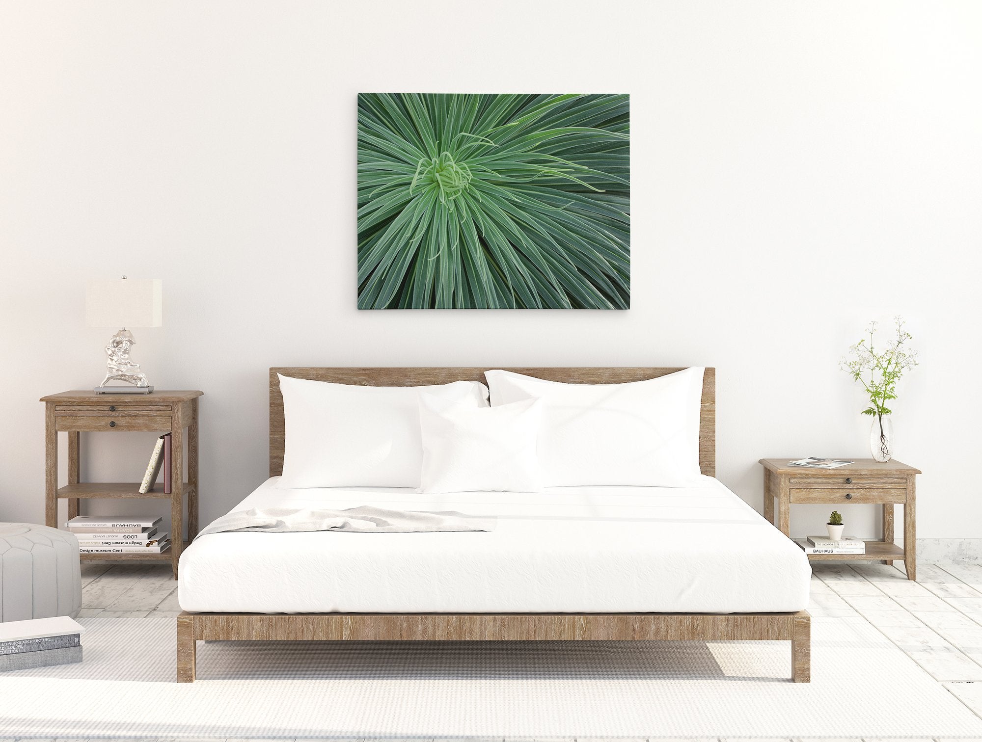 A minimalist bedroom featuring a neatly made bed with white linens, wooden side tables with lamps, and a large Offley Green Abstract Green Botanical Canvas Wall Art, &#39;Desert Fireworks&#39; above the bed.